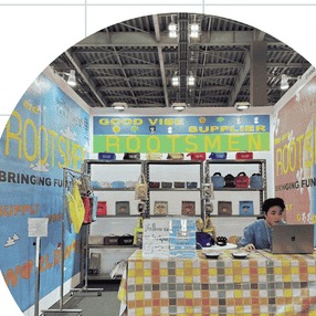 El stand de ROOTSMEN con su muro de productos y su mesa de reuniones